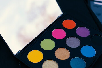 
two makeup palettes on wooden background, closeup