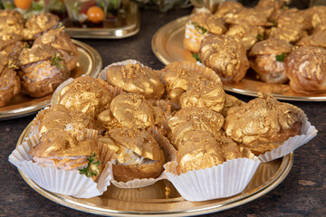 festive eclairs decorated with liquid gold served on a Golden plate