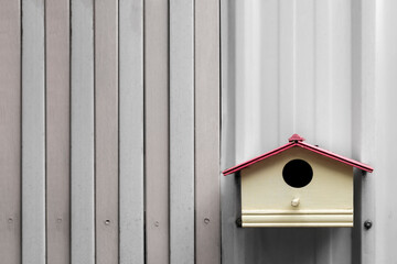 Empty wooden pastel colored of birdhouse on the old white wall background. Selective focus and copy space.