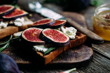 Toast with cream cheese, figs and honey on the table