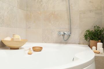 Bath with personal hygiene accessories in light beige bathroom