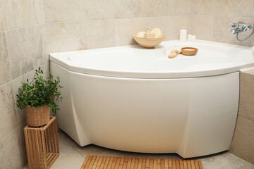 Bath with personal hygiene accessories in light beige bathroom