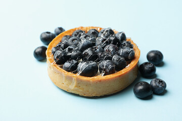 Blueberry pie on blue background, close up