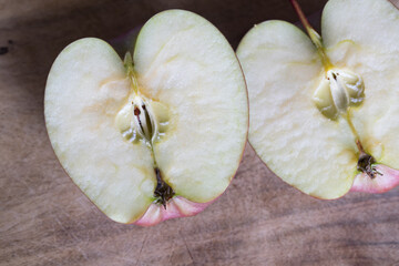 apple cut in half on wooden cutting board