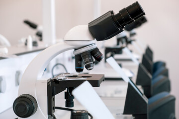 Microscope on table in the laboratory. Line of microscopes on tables in a hospital laboratory without people.