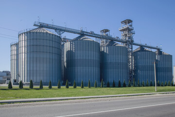 Granary. A large modern agro-processing plant for the storage and processing of grain crops. Large metal barrels of grain. Granary elevator. Horizontal image.