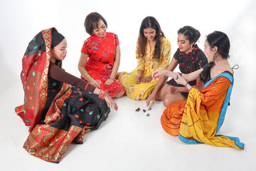 Obraz premium South east Asian Malay Chinese Indian race ethnic origin woman wearing dress costume baju kurung cheongsam samfu kebaya Sharee multiracial community playing Batik Batu Seremban on white background