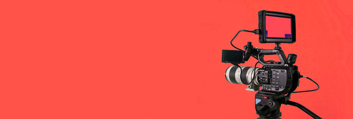 Video camera on red background, broadcasting banner with copy space