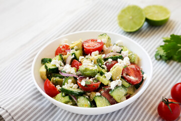 Delicious Avocado Tomato and Cucumber Salad in a bowl, low angle view.