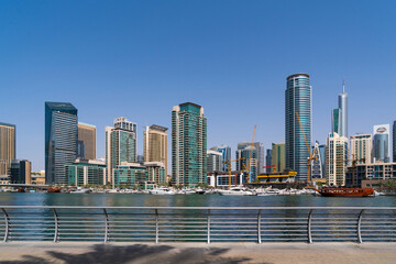 Fototapeta na wymiar Luxury Dubai Marina skyscrapers at financial district and promenade in beautiful summer day. Futuristic cityscape of the capital of the Emirate of Dubai. Business hub of Western Asia
