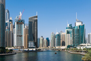 Fototapeta na wymiar Residential towers and villas of Dubai Marina at a sunny day. Panorama cityscape of futuristic skyscrapers. Business hub of international trading and financial services of Western Asia