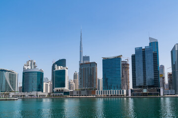 Fototapeta na wymiar Panoramic view of skyscrapers of downtown of Dubai, UAE at Dubai Canal, Business Bay. Modern cityscape of the capital of the Emirate of Dubai. A center of new financial tech of Western Asia