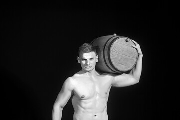 Sexy man with a muscular body working in half naked with a barrel of beer.