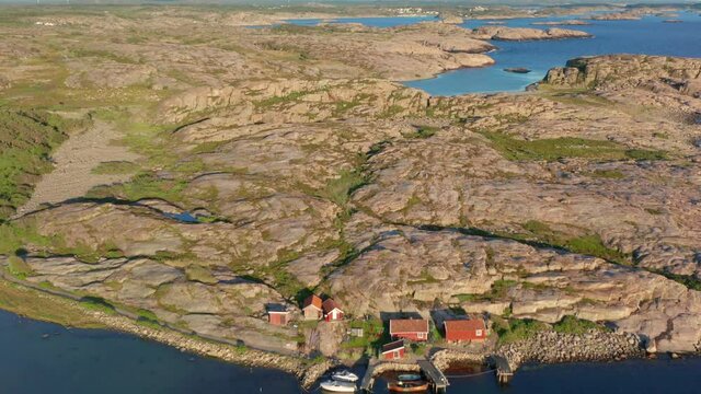 Granite rock formations on Swedish west coast bohuslan. Aerial drone shot of nature with flat stones and gravel. Few small fishing houses. Green vegetation and plenty of bare rocks and cliffs. Sweden