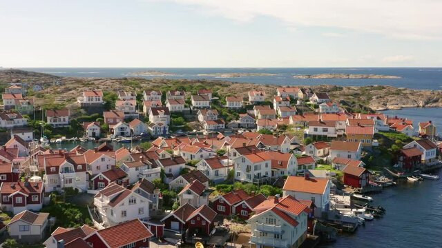 Sweden coastline aerial view. Drone shot of small island on idyllic swedish west coast. Summer time in Bohuslan close to Gothenburg. Gullholmen island with tightly narrow built wooden homes at ocean