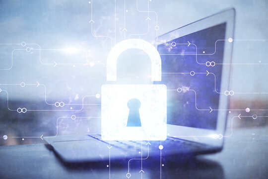 Double exposure of desktop with computer and lock icon hologram. Concept of data safety.