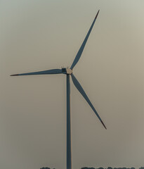 Wind turbine generating green energy in the evening light.