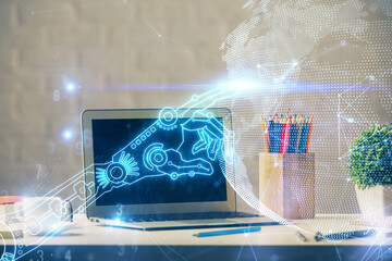 Computer on desktop in office with technology theme hologram. Double exposure. Tech concept.