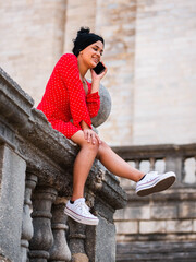 Business woman with red dress in outdoors talking on mobile phone