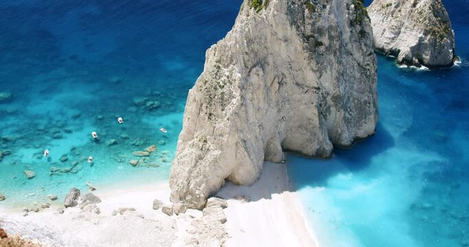 Remote beach with huge white rock formation with blue lagoon, tourist pleasure boats. Top view