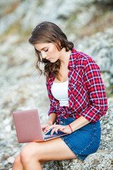 Office outdoors. Beautiful girl works on a laptop in the open air. woman freelancer. Freelance worker concept.