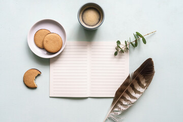 Obraz na płótnie Canvas Ein unbeschiebenes Notizbuch mit einer Tasse Kaffee, Keksen und einer Feder auf einem neutralen Hintergrund. Flat lay, Tagebuch, Brief schreiben.
