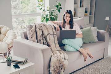 Photo portrait of relaxed woman sitting on sofa with laptop indoors