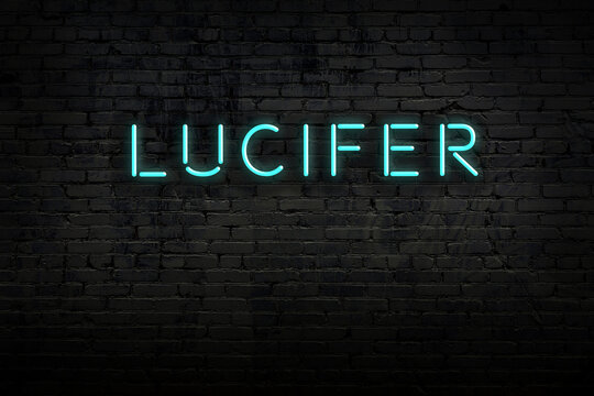 Neon sign. Word lucifer against brick wall. Night view