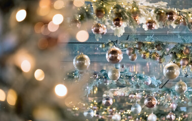 Fototapeta premium Ceiling christmas decorations in modern mall, shopping center or exhibition place on blurred bokeh background. Baubles hanging on trees branch