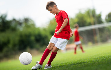 Young boy shooting soccer ball