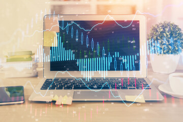 Financial graph colorful drawing and table with computer on background. Double exposure. Concept of international markets.