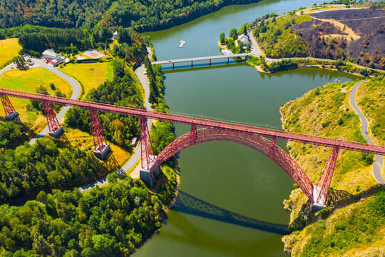 Scenic drone view of parabolic arched framework of railway bridge Viaduc de Garabit across river Truyere near Ruynes-en-Margeride in Auvergne, France..