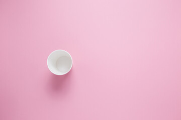 Fototapeta na wymiar Paper cup for hot coffee or tea on a pink isolated background.