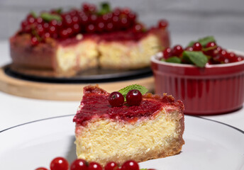 Cheesecake with red currant and mint on wooden board. Top view.