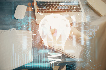 Drawing bulb over woman's hands taking notes background. Concept of idea. Double exposure