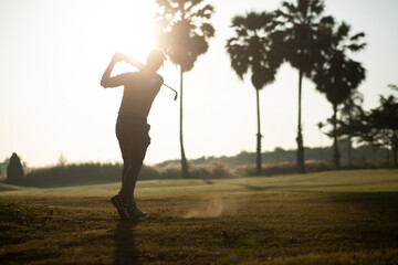 Golfer he's golfing in sunlight of the morning. View from the back. Silhouette of Golfer.