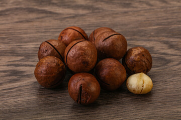 Brown macadamia nut heap over background