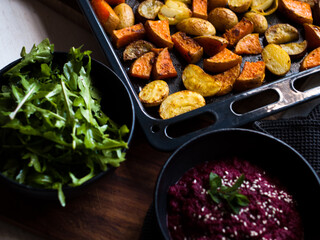Home made roast vegetables with arugula and beetroot puree. Natural light.