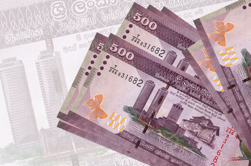 500 Sri Lankan rupees bills lies in stack on background of big semi-transparent banknote. Abstract...