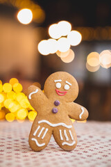 Merry Christmas and Happy New Year: Concept for a cafe or bakery, a photo of a cool gingerbread cookie standing in front of a Christmas tree and garlands