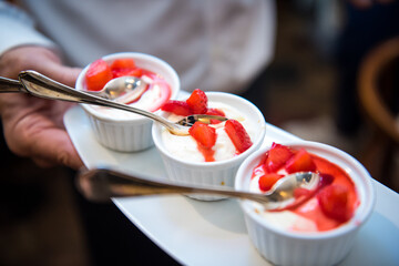 mini panna cotta al cucchiaio con fragole fresche su vassoio bianco