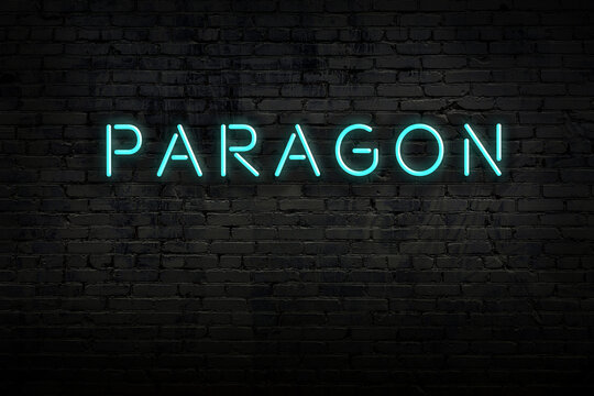 Night view of neon sign on brick wall with inscription paragon