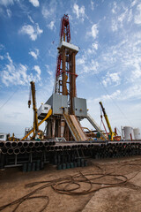 Drilling rig, cranes and equipment on oil deposit. Oil workers on drilling pipes. Uralsk region, Kazakhstan. 