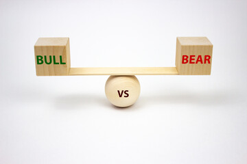 Bull vs bear lettering on wooden cubes scales on a white background. The concept of exchange trading of buyers and sellers. Balance of bulls and bears on the stock exchange.