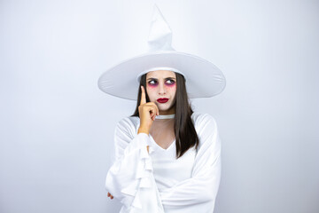 Woman wearing witch costume over isolated white background thinking and looking to the side