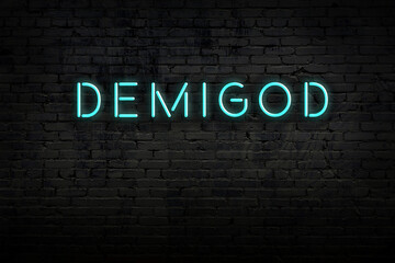 Night view of neon sign on brick wall with inscription demigod