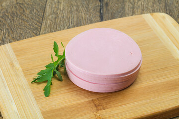 Sliced sausage over the wooden board