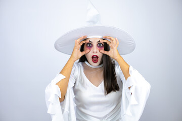 Woman wearing witch costume over isolated white background Trying to open eyes with fingers, sleepy and tired for morning fatigue
