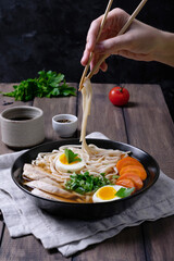 Person eating asian ramen soup with chicken