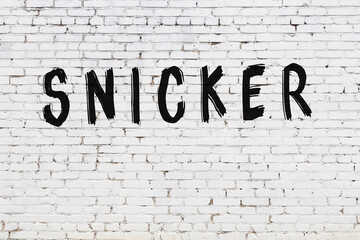 Inscription snicker painted on white brick wall